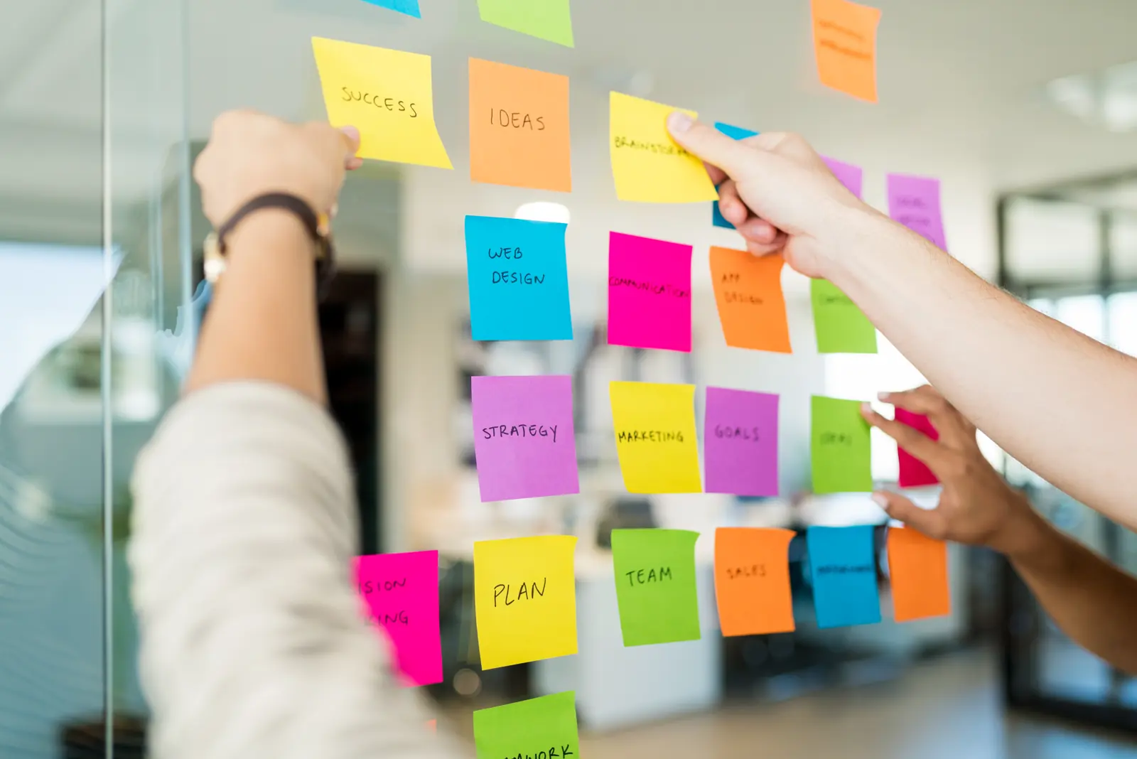 Haftnotizen an einer Glaswand während eines Workshops
